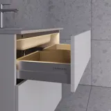 Große Badezimmerinspiration im nordischen Stil mit Badezimmerschränken in hellblauer Farbe und Holzarbeitsplatte mit elegantem Aufsatzwaschbecken, Fischgrät-Holzboden, der einen hellen und klassischen Stil schafft